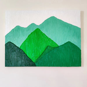 Close-up of handmade textured mountain landscape painting in vibrant green tones.