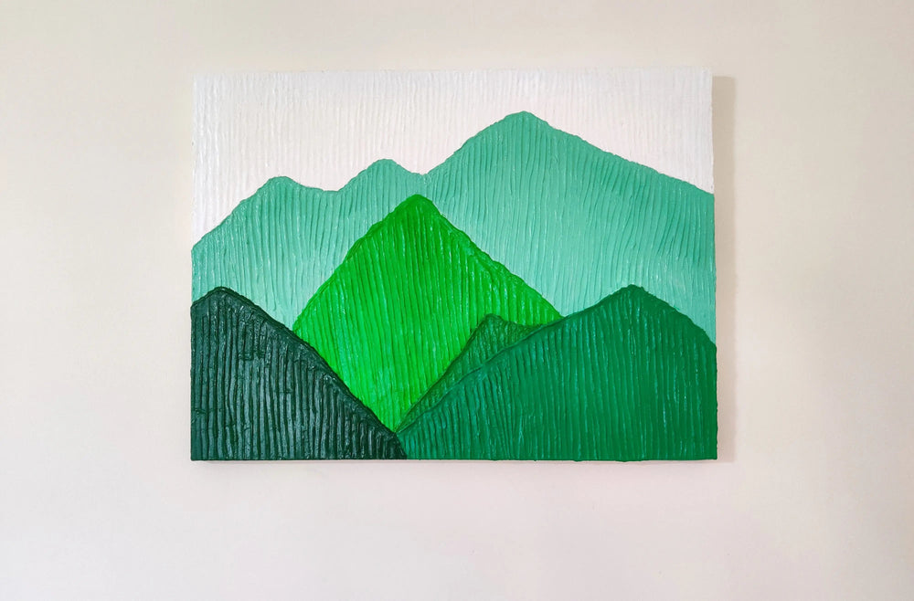 Close-up of handmade textured mountain landscape painting in vibrant green tones.