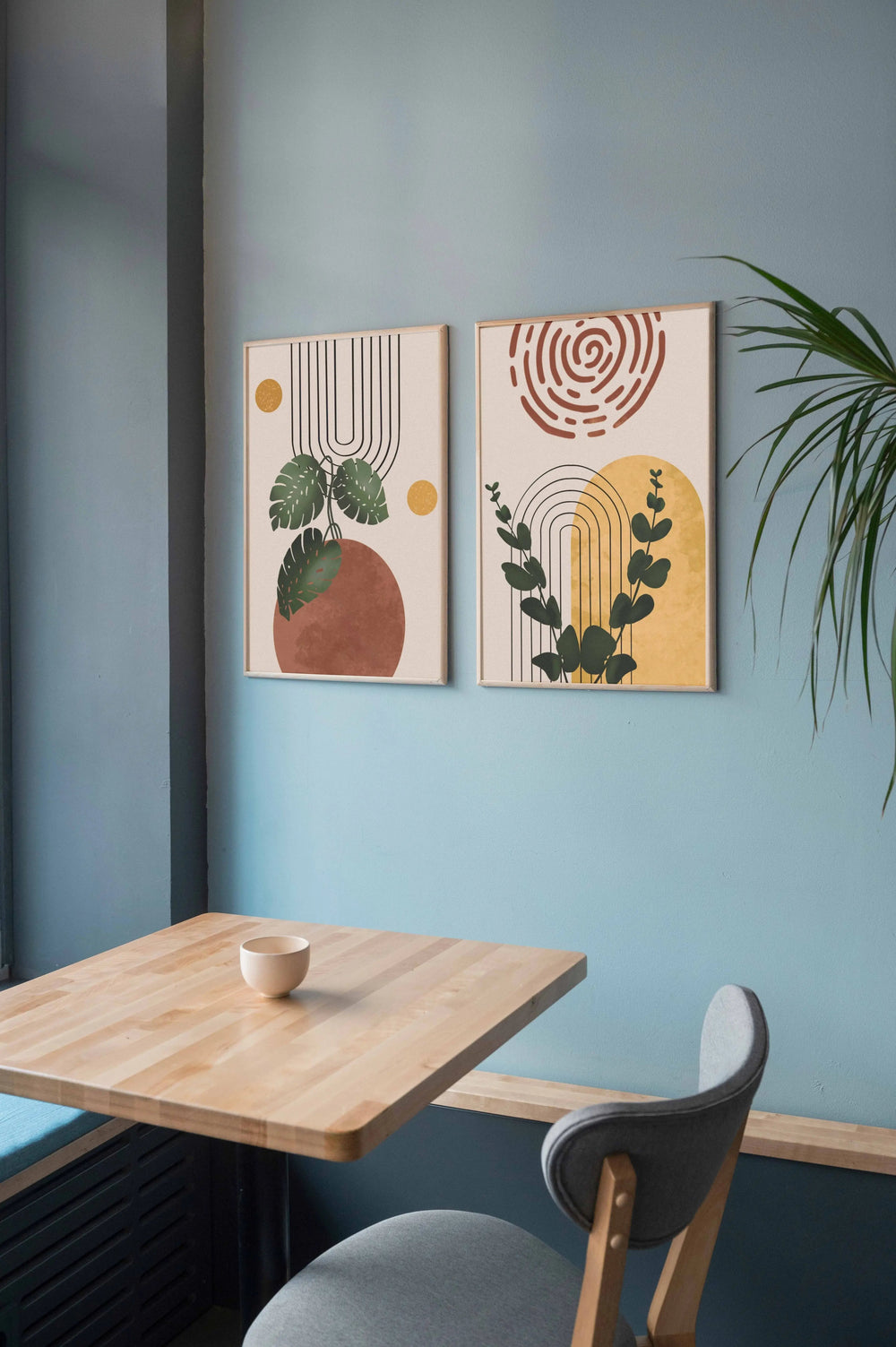 Modern boho digital artwork with leafy designs displayed in a cafe setting.