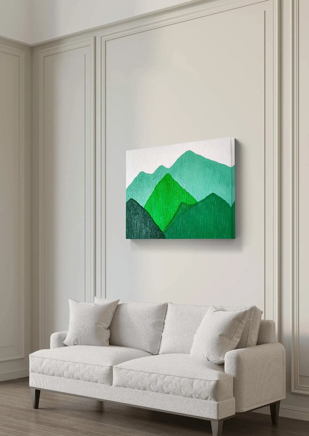 Green mountain landscape painting hung above a white sofa in a minimalist living room.