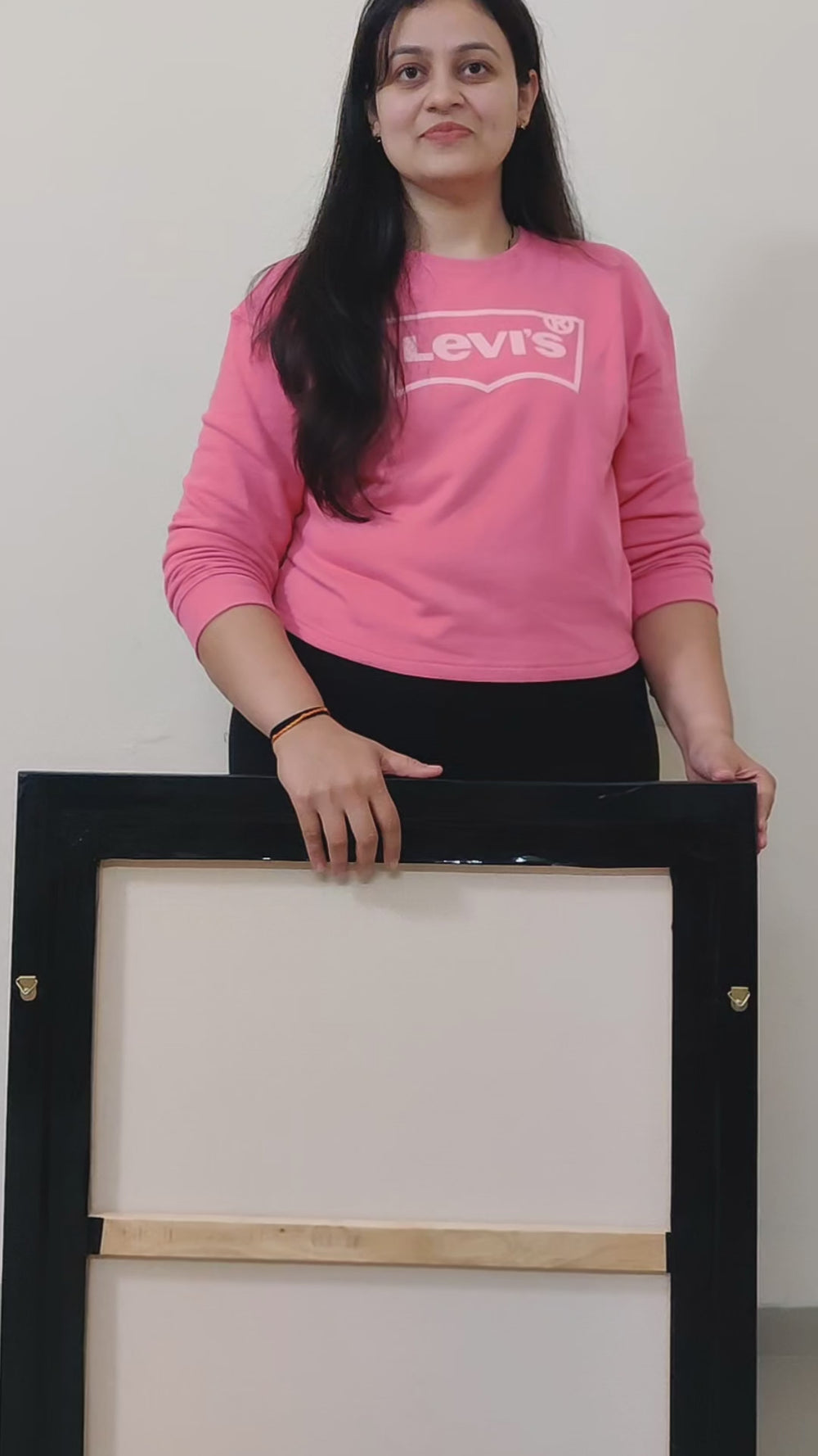 Back view of the framed Lord Shiva canvas held by a person in casual attire.