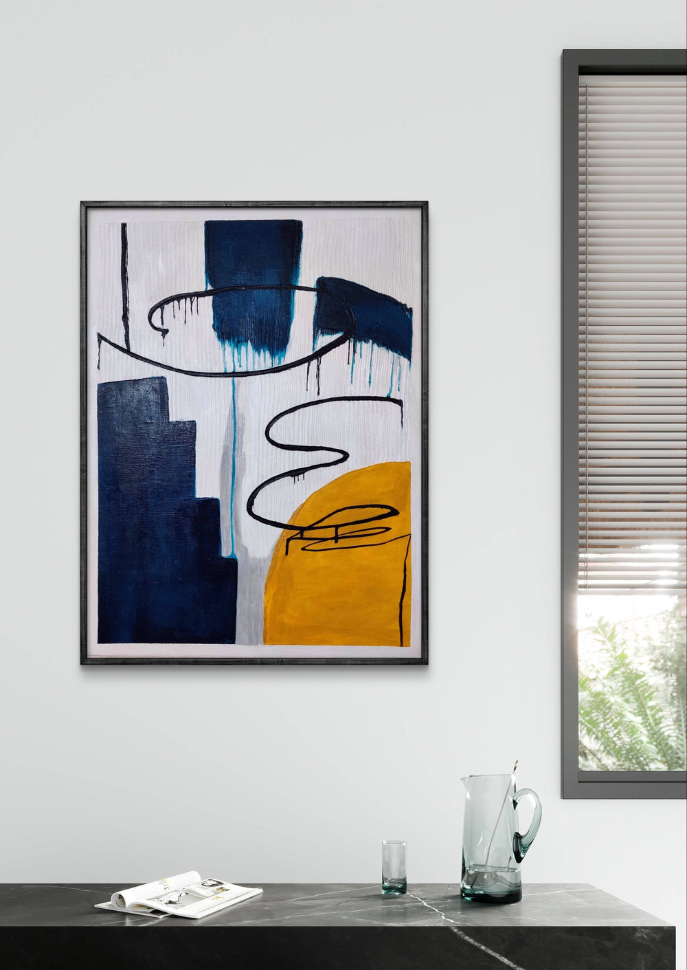 Abstract handmade painting with bold blue and yellow tones in a sleek, minimalist room.
